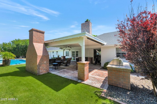 rear view of property featuring ceiling fan, a patio area, and area for grilling