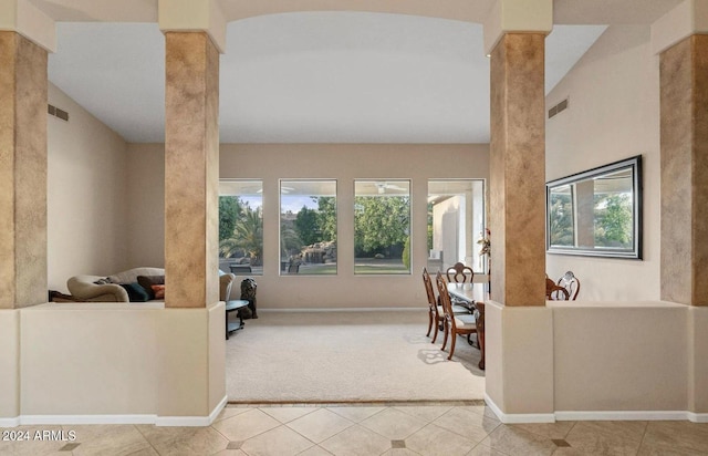 carpeted living room featuring decorative columns, plenty of natural light, and lofted ceiling