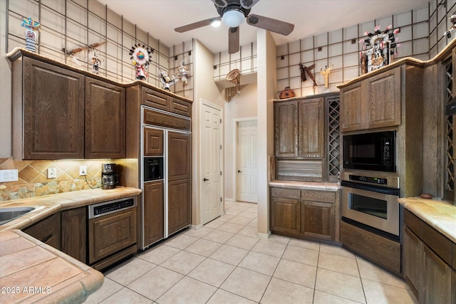 41910 N Long Cove Way, Anthem, AZ 85086 - kitchen featuring ceiling fan, dark brown cabinets, decorative backsplash, tile counters, and built in appliances