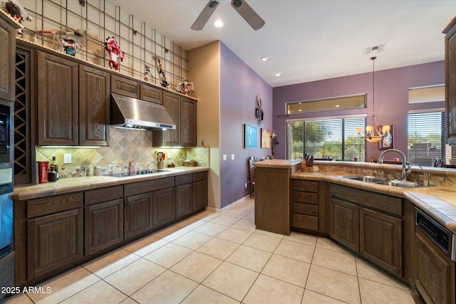 41910 N Long Cove Way, Anthem, AZ 85086 - kitchen featuring dark brown cabinetry, black electric stovetop, tile counters, extractor fan, and a sink