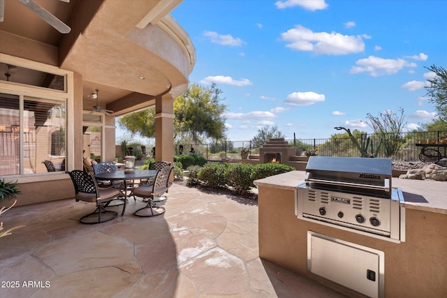 41910 N Long Cove Way, Anthem, AZ 85086 - view of patio / terrace with outdoor dining space, an outdoor kitchen, a grill, ceiling fan, and fence