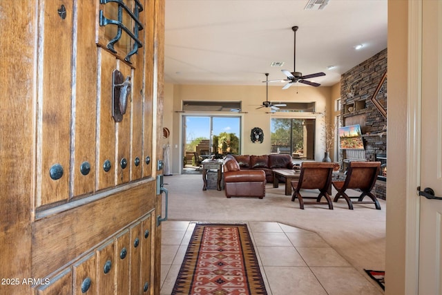 41910 N Long Cove Way, Anthem, AZ 85086 - carpeted foyer with visible vents, a ceiling fan, tile patterned flooring, and a fireplace