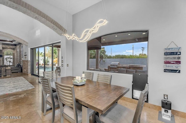 dining area featuring a high ceiling and an inviting chandelier