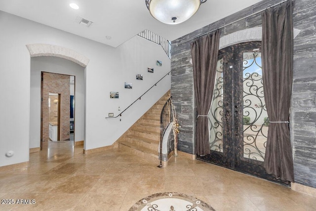 tiled foyer entrance featuring stairs, french doors, baseboards, and visible vents