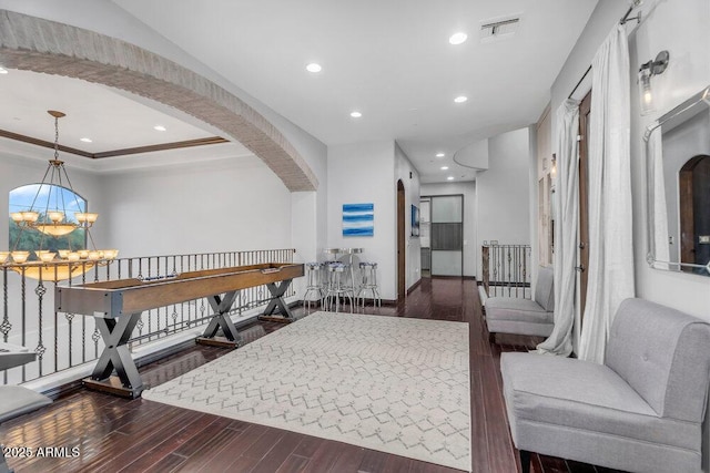 hallway featuring an inviting chandelier, arched walkways, visible vents, recessed lighting, and wood finished floors