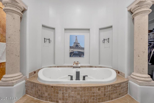 bathroom featuring ornate columns and a garden tub
