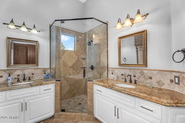 bathroom with a sink, two vanities, and a stall shower