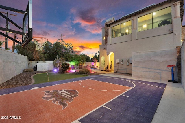 view of basketball court featuring basketball court and fence