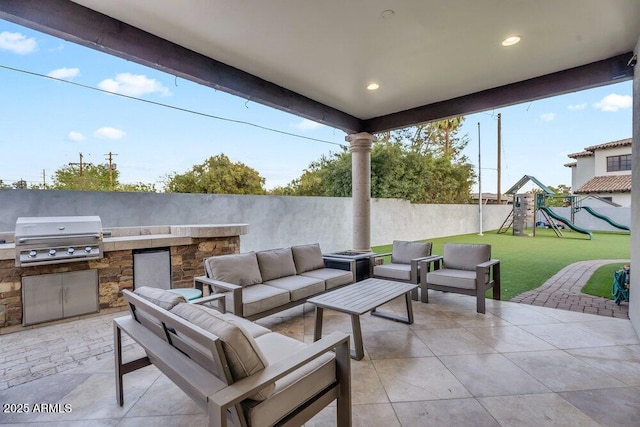 view of patio with a grill, outdoor lounge area, a fenced backyard, a playground, and an outdoor kitchen