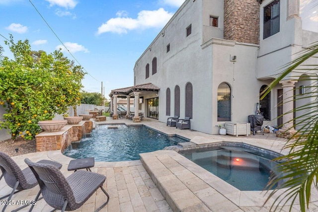 view of swimming pool featuring a patio area, a pool with connected hot tub, and fence