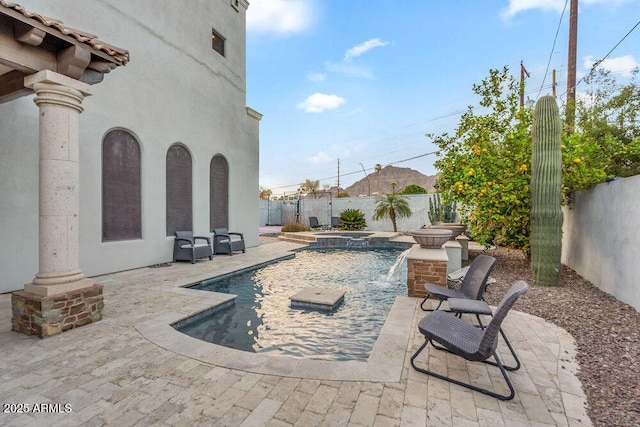 view of swimming pool featuring a patio, a fenced backyard, and a pool with connected hot tub