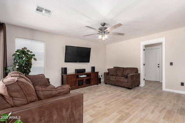 living area featuring a ceiling fan, light wood-type flooring, and baseboards