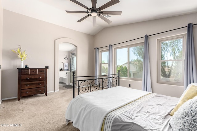bedroom featuring arched walkways, light colored carpet, lofted ceiling, baseboards, and a ceiling fan