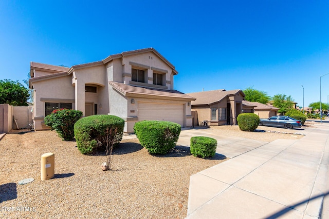 view of front facade featuring an attached garage, driveway, stucco siding, and fence