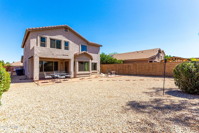 back of property featuring a fenced backyard, a patio area, and stucco siding
