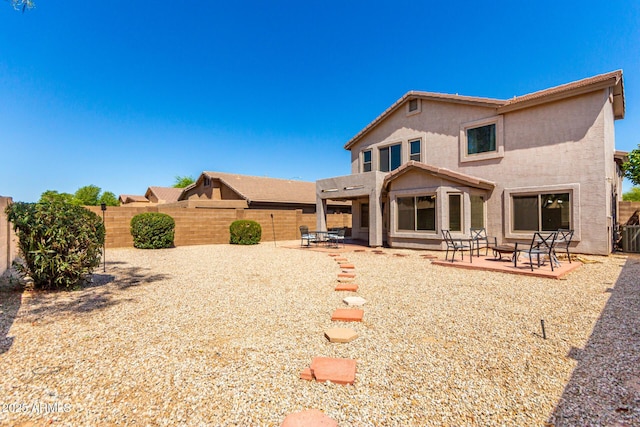 back of property with a fenced backyard, a patio, and stucco siding