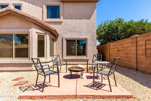 view of patio featuring an outdoor fire pit and fence