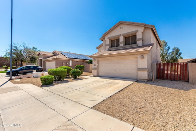 view of front of house featuring concrete driveway, an attached garage, stucco siding, fence, and a gate