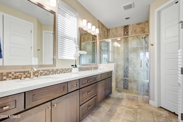 bathroom with vanity, tasteful backsplash, tile patterned floors, and a shower with door