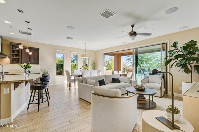 living room featuring plenty of natural light, light hardwood / wood-style floors, and ceiling fan