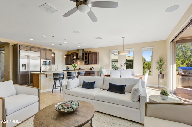 living room with light hardwood / wood-style floors and ceiling fan