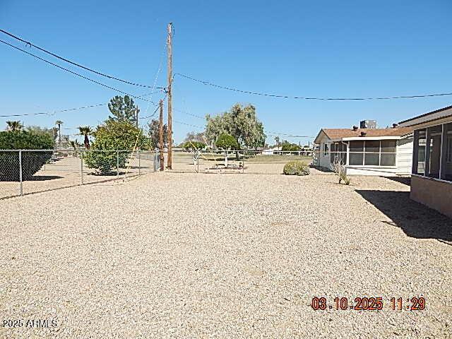 view of yard with fence and a sunroom