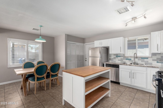 kitchen with white cabinetry, appliances with stainless steel finishes, sink, and pendant lighting