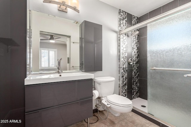 bathroom featuring toilet, vanity, tile patterned floors, and a shower with shower door