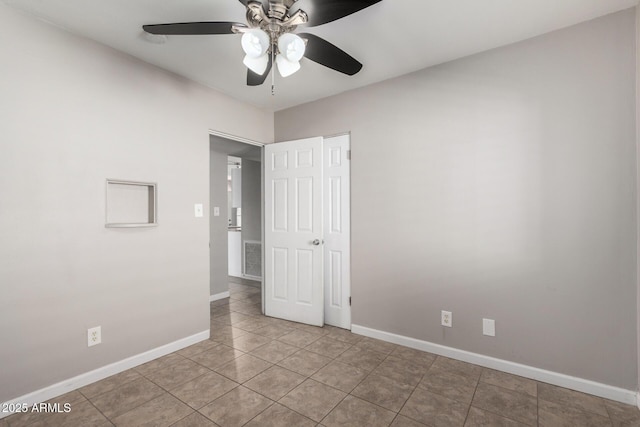 unfurnished room with ceiling fan and light tile patterned floors