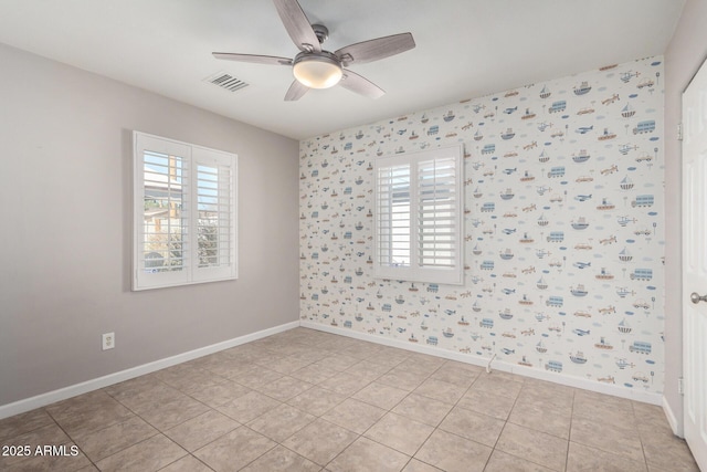 tiled spare room featuring a healthy amount of sunlight and ceiling fan