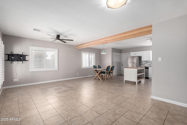 interior space with ceiling fan, light tile patterned flooring, and beam ceiling