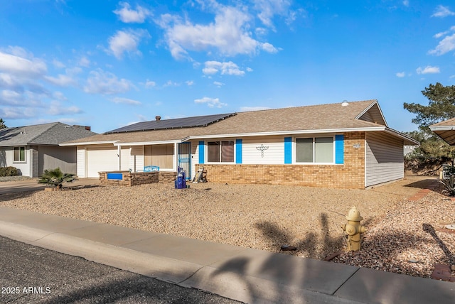 ranch-style home with solar panels and a garage