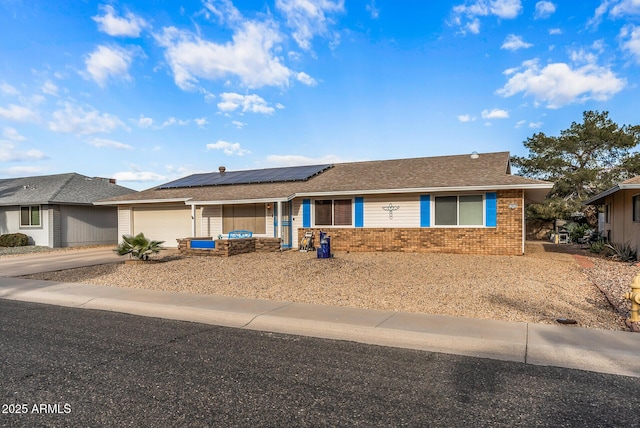 ranch-style house featuring solar panels and a garage