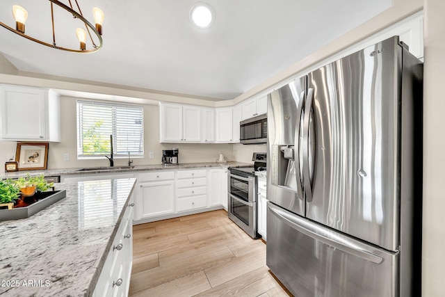 18644 N 21st St, Phoenix, AZ 85024 - kitchen with stainless steel appliances, a sink, white cabinets, light stone counters, and light wood-type flooring