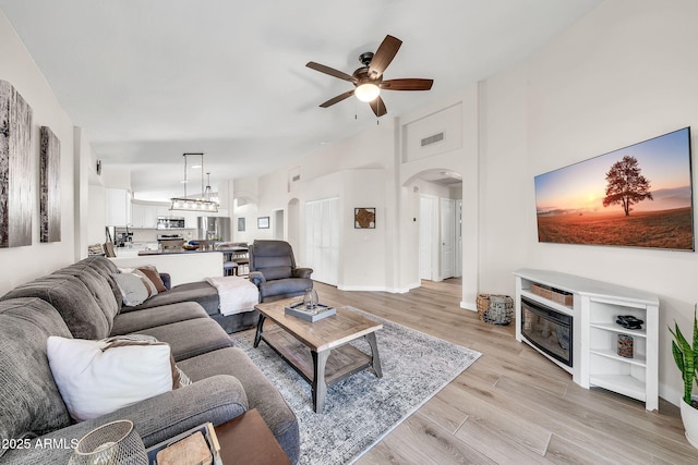 18644 N 21st St, Phoenix, AZ 85024 - living room featuring arched walkways, a ceiling fan, light wood-style floors, and baseboards