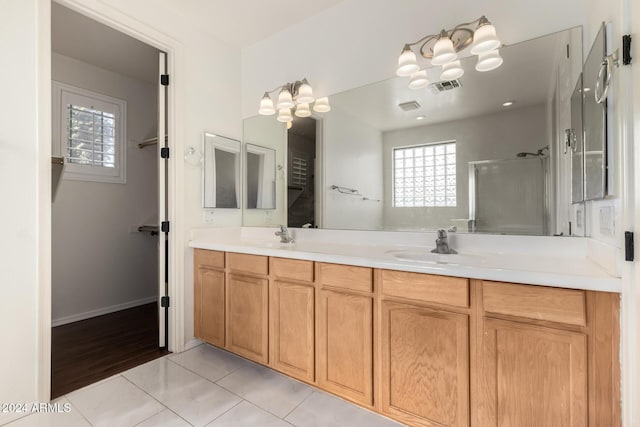 bathroom with tile patterned flooring, vanity, and a shower with shower door