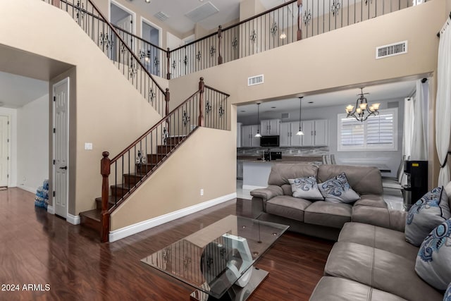 living room featuring a chandelier, dark hardwood / wood-style flooring, a towering ceiling, and sink