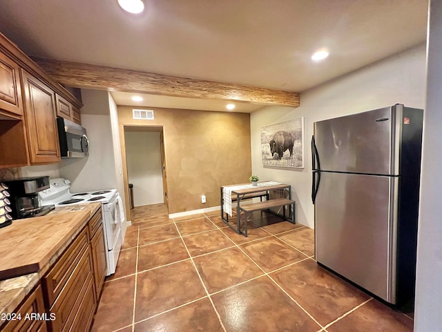 kitchen featuring appliances with stainless steel finishes, tile flooring, and beamed ceiling