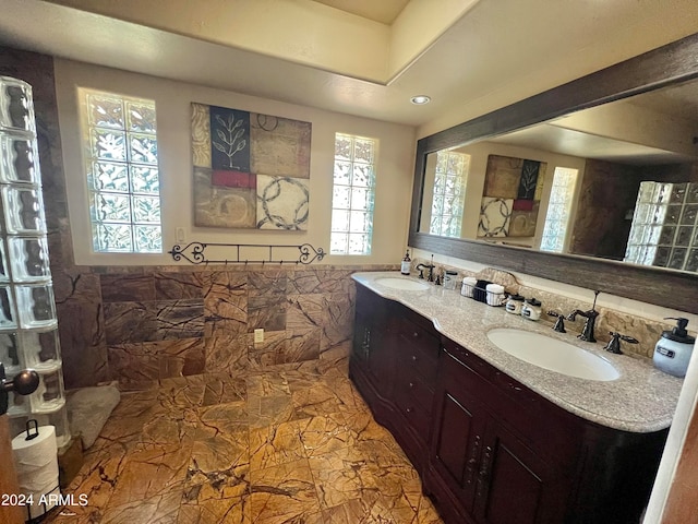 bathroom featuring tile floors, dual sinks, large vanity, and a wealth of natural light