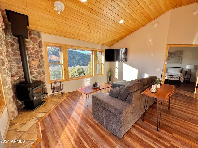 living room featuring lofted ceiling, a wood stove, wood ceiling, and light hardwood / wood-style floors