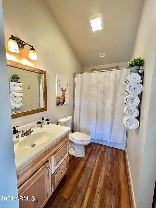 bathroom featuring lofted ceiling, vanity, toilet, and hardwood / wood-style floors