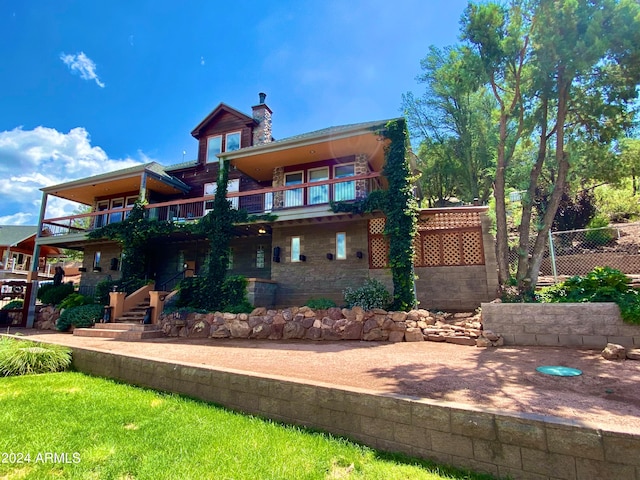 rear view of property featuring a balcony