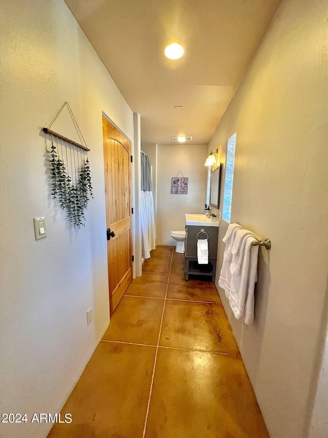 hallway with light tile flooring and sink