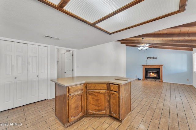 3046 E Dover St, Mesa, AZ 85213 - kitchen with a ceiling fan, a glass covered fireplace, light countertops, light wood-type flooring, and open floor plan