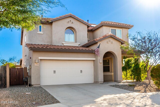 mediterranean / spanish house featuring fence, a tiled roof, concrete driveway, stucco siding, and an attached garage