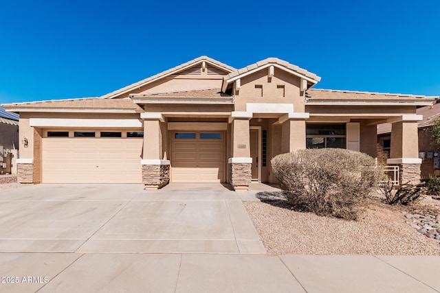 view of front of property featuring driveway, stone siding, a tiled roof, an attached garage, and stucco siding