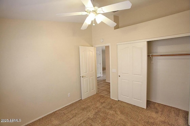 unfurnished bedroom featuring a closet, ceiling fan, carpet, and vaulted ceiling