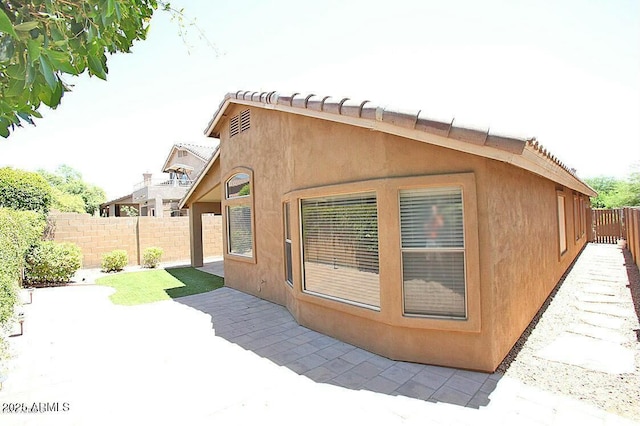 view of property exterior with a patio, a fenced backyard, and stucco siding