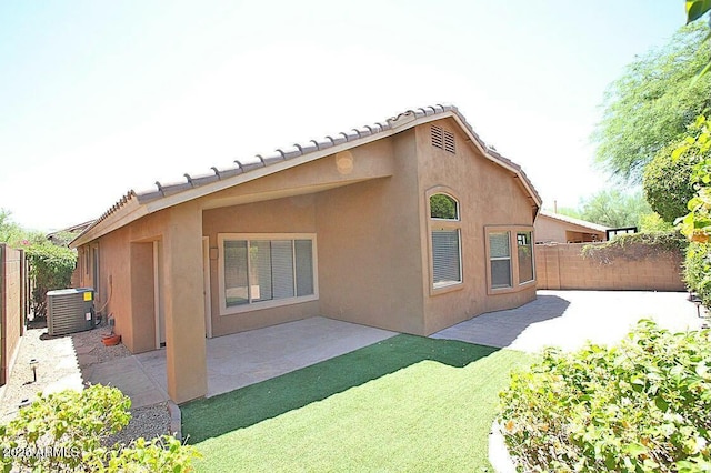 rear view of property featuring a patio area, stucco siding, fence private yard, and central AC