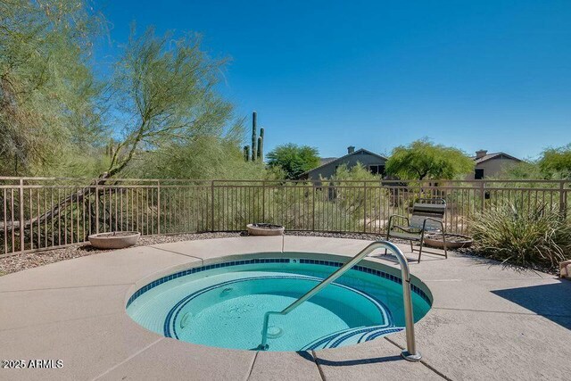 view of swimming pool featuring a patio area, an in ground hot tub, and fence